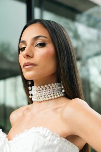 Photo de presse de KRN en tenue blanche avec collier de perles, regard affirmé, pour la sortie de son premier album Mawja.